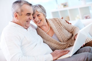 Couple aged 55+ exploring retirement communities on their computer